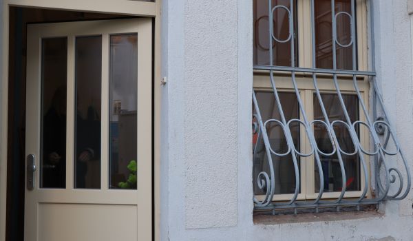 Eine offne Tür neben einem Fenster.