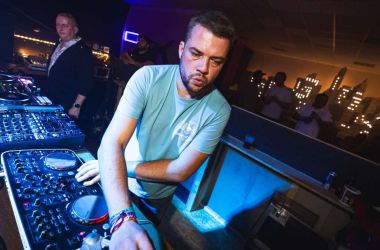 Ein Mann steht an einem Mischpult und legt auf.