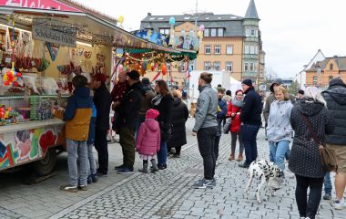 Menschen vor einem Verkaufstand für Süßwaren.