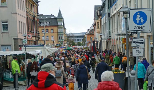 Eine große Menge von Menschen läuft durch die Fußgängerzone der Stadt Sonneberg. An der rechten Seite sind Verkaufsstände aufgebaut.