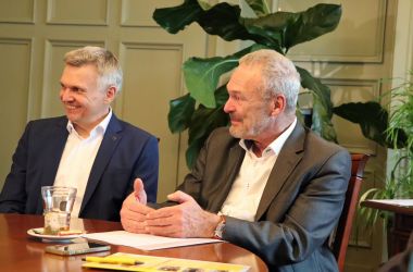 Zwei Männer sitzen an einem Tisch.