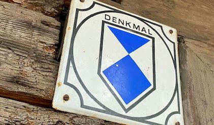 Ein blau-weißes Schild mit der Aufschrift Denkmal.