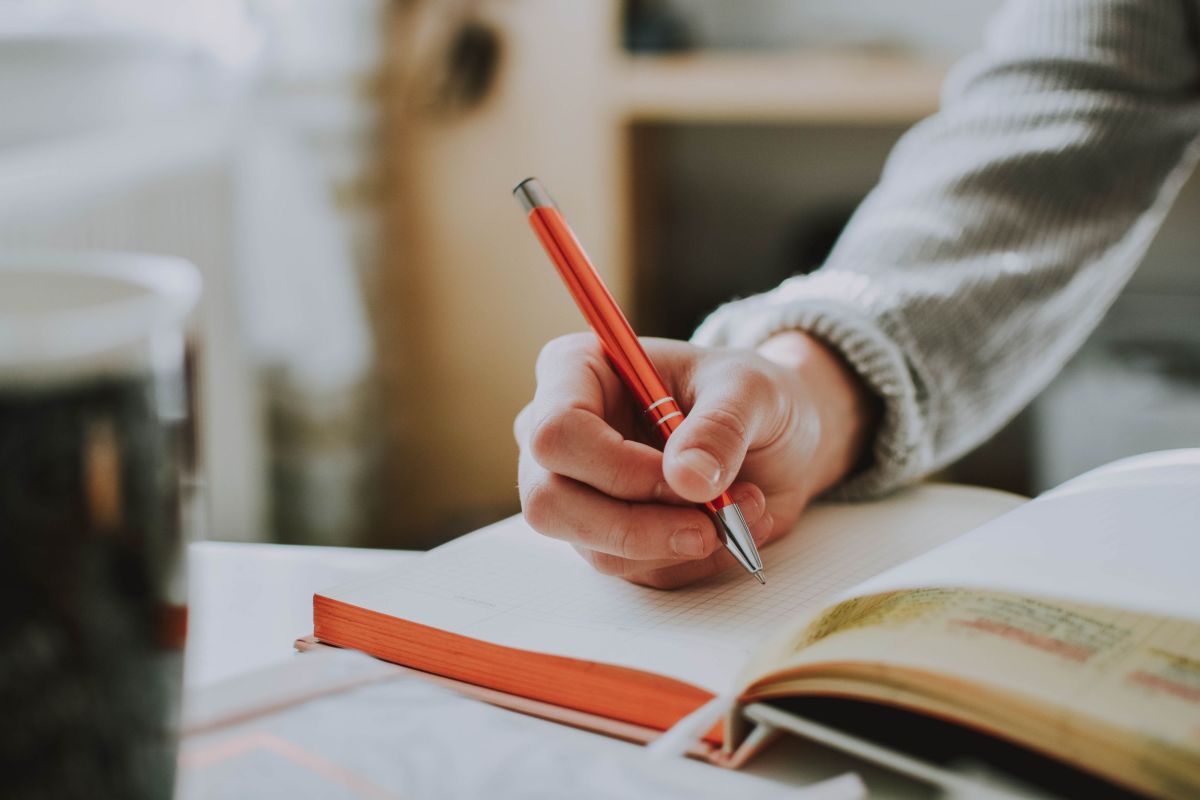 Hand, die einen Stift hält, und Notizen macht, Foto: Pexels.com / Lilartsy
