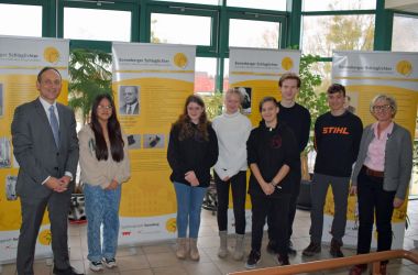 Schüler und zwei Erwachsene stehen vor verschiedenen Bannern mit der Aufschrift: Sonneberger Schlaglichter.