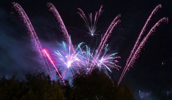 Ein Feuerwerk mit blauen und pinken Lichteffekten bei Nacht.