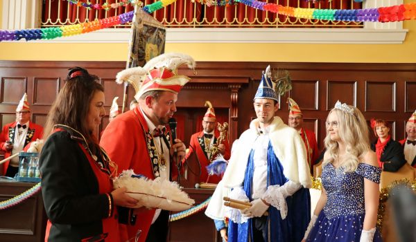 Ein Mitglied des Elferrats überreicht ein Präsent an das Prinzenpaar.