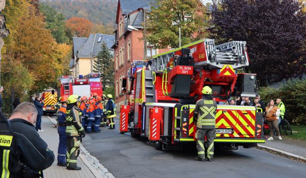 Der Drehleiterwagen der Feuerwehr steht auf einer Straße.