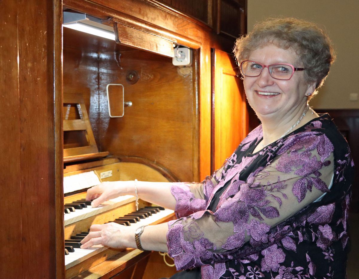 Eine Frau sitzt an einer Orgel und spielt.
