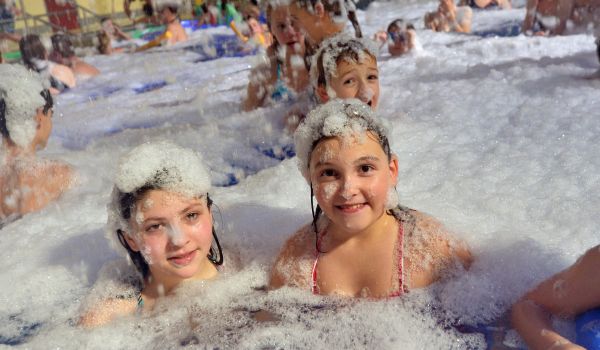 Kinder in einem Becken mit Schaumwasser.