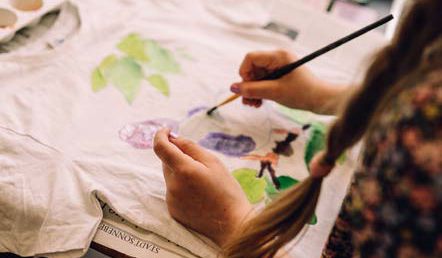 Ein Kind bemalt eine T-Shirt.