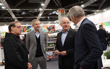 Vier Männer unterhalten sich auf einer Messe.