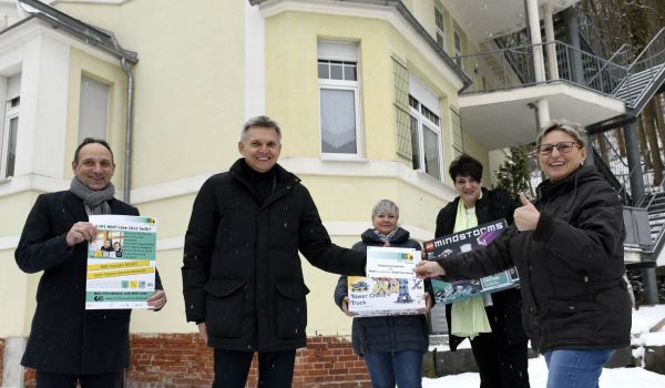 Zwei Männer überreichen ein Mint-Partnerschaftsschild und Technikbaukästen an drei Frauen. Es sind der Bürgermeister Dr. Heiko Voigt und der hauptamtliche Beigeordnete Christian Dressel.