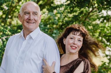 Eine Frau und ein Mann stehen in einem Wald.