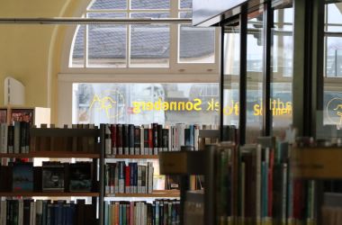 Regale mit Büchern stehen in einem Gebäude.