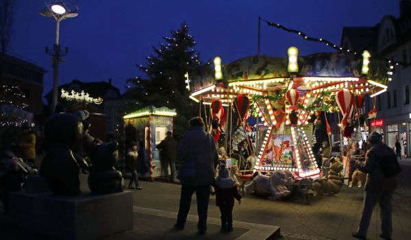 Ein Kinderkarussell ist am Abend beleuchtet.