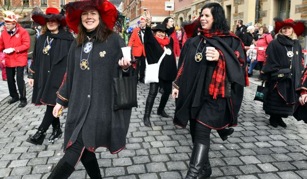 Frauen in schwarzer Kleidung mit rotem Hut.