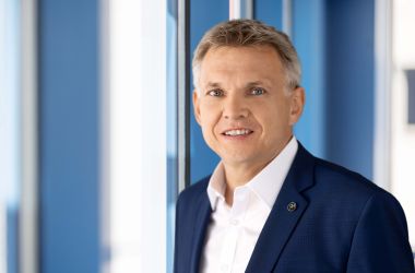 Ein Mann im Anzug steht vor einem Fenster. Es ist der Bürgermeister Dr. Heiko Voigt.