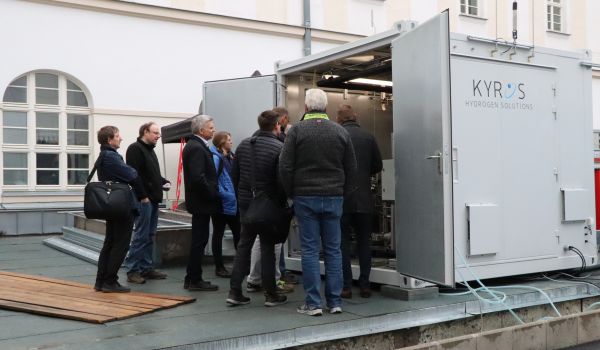 Interessierte Gäste schauen in einen Container.