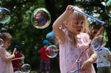 Kinder machen Seifenblasen.