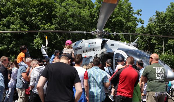 Menschen stehen vor einem Poliezi-Hubschrauber.