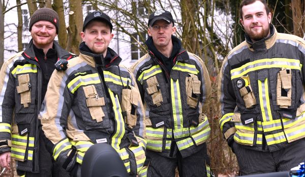 Vier Männer in Feuerwehr-Uniform.