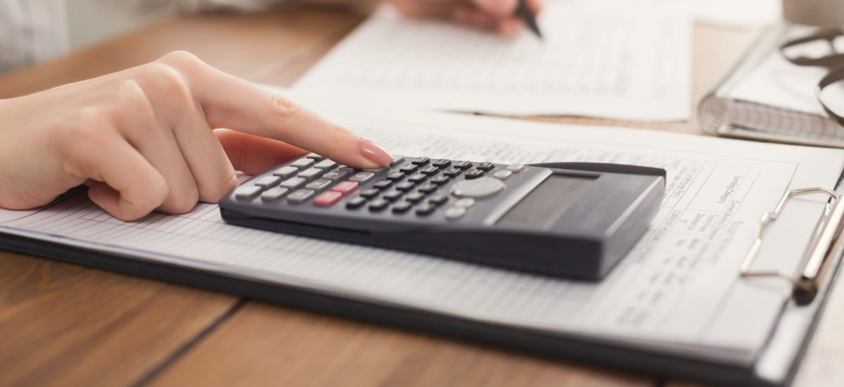 Eine Frau rechnet mit einem Taschenrechner.