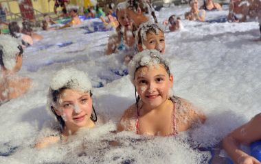 Kinder in einem Becken mit Schaumwasser.