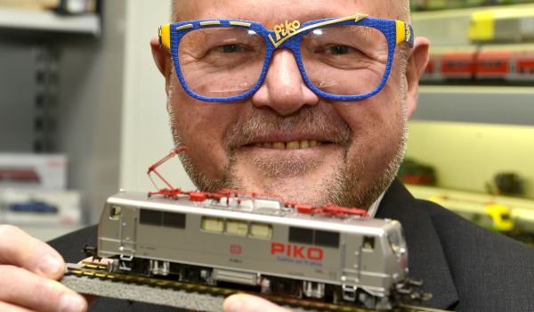 Spielwarenhersteller und PIKO Chef Dr. René Wilfer mit einer Eisenbahn in der Hand.