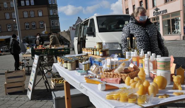 An einem Marktstand werde verschiedene Produkte mit Honig und Wachs angeboten.
