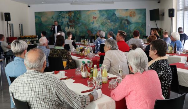 Menschen sitzen an gedeckten Tischen im Gebäude der Wolke 14.