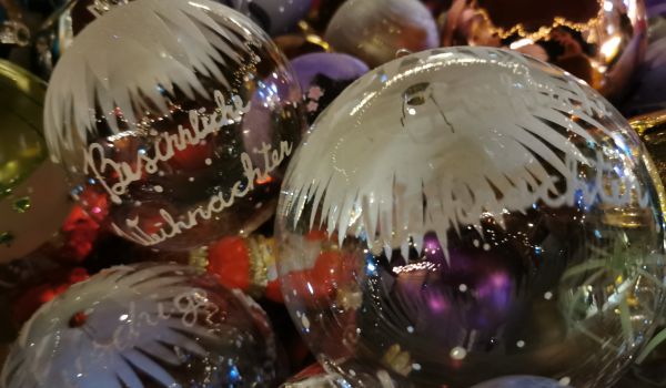 Durchsichtige Glaskugeln mit der Aufschrift: Besinnliche Weihnachten.