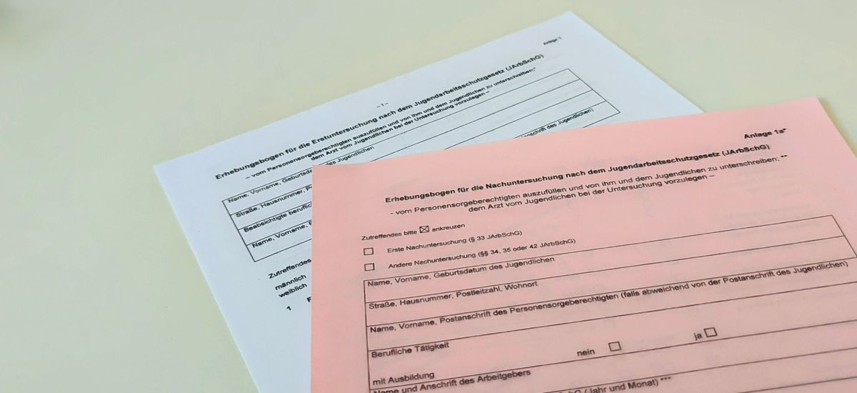 Zwei Dokumente liegen auf einem Tisch.