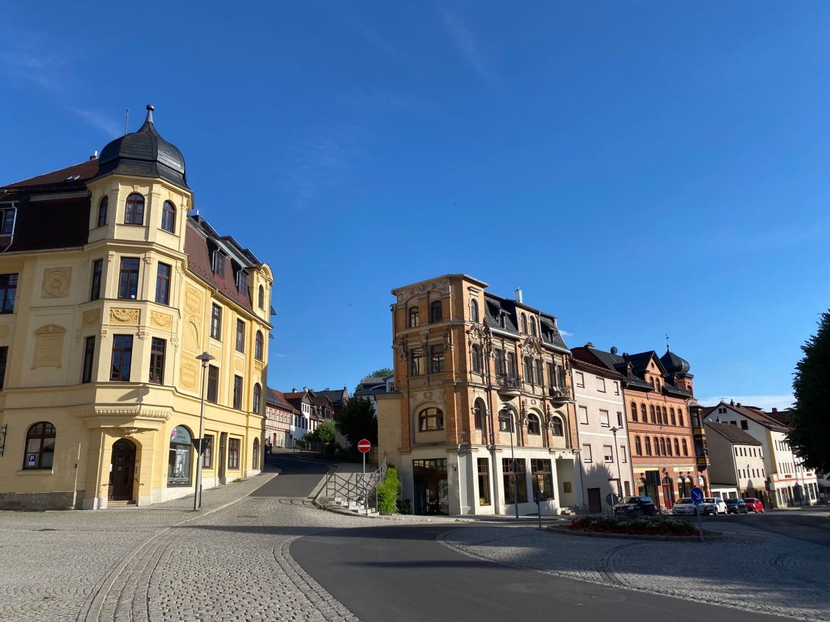Eine Häuserreihe in der Altstadt Sonneberg. Eine Straße verläuft zwischen den Häusern.
