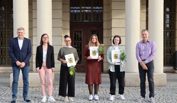 Menschen stehen vor dem Rathaus.