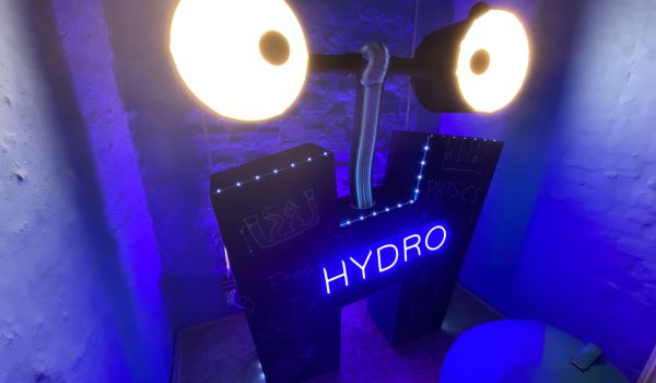 Auf einer H-förmigen Schild leuchtet das Wort ''Hydro'' blau.