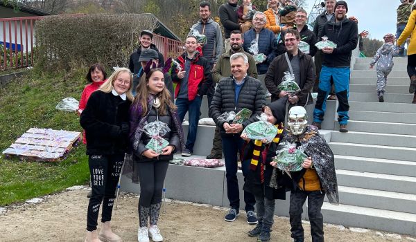 Kinder und Erwachsene stehen auf Treppenstufen in einer Park- und Spielanlage.