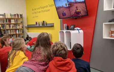 Kinder schauen auf einen Bildschirm mit Videospielen.