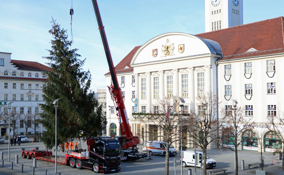 Vor dem Sonneberger Rathaus stellt ein Kran einen großen Weihnachtsbaum auf.
