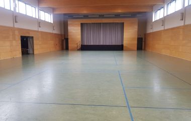 Eine Sporthalle mit Bühne.