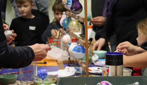 Kinder bemalen an einem Stand Glaskugeln.
