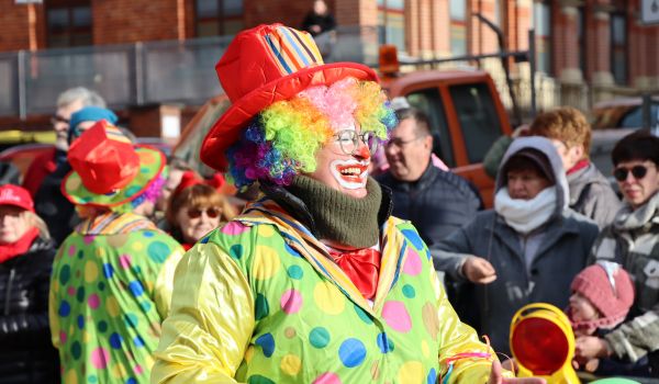 Zwei kostümierte Clowns laufen beim Umzug mit.