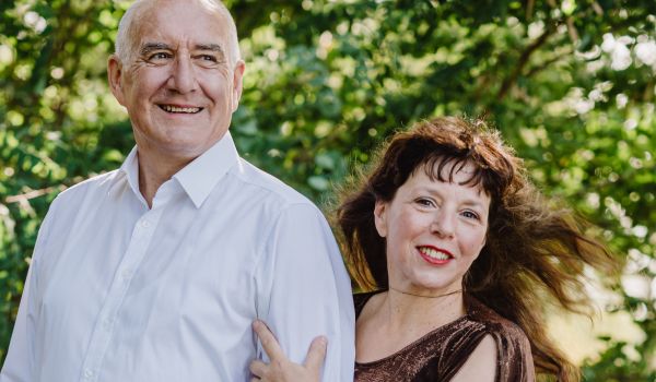 Eine Frau und ein Mann stehen in einem Wald.