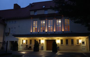Ein großes Gebäude ist bei Nacht beleuchtet.