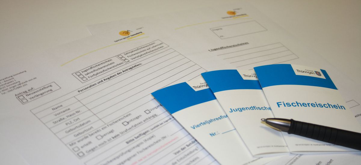 Die verschiedenen Arten von Fischereischeinen auf einem Tisch.