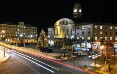 Es ist dunkel. Das Sonneberger Rathaus. Davor steht ein beleuchteter Weihnachtsbaum.