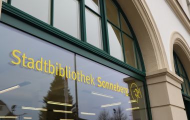 Der Schriftzug Stadtbibliothek Sonneberg steht an einer Fensterscheibe.