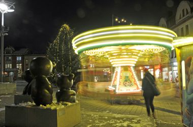 Ein Kinderkarussell ist am Abend beleuchtet.