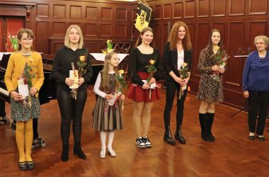 Kinder und Jugendliche stehen in einer Reihe und halten ein Präsent in den Händen.