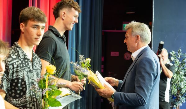 Der Bürgermeister überreicht Präsente.