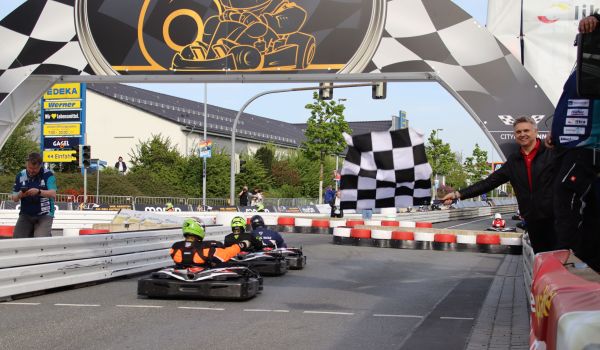 Kartfahrer fahren durchs Ziel.